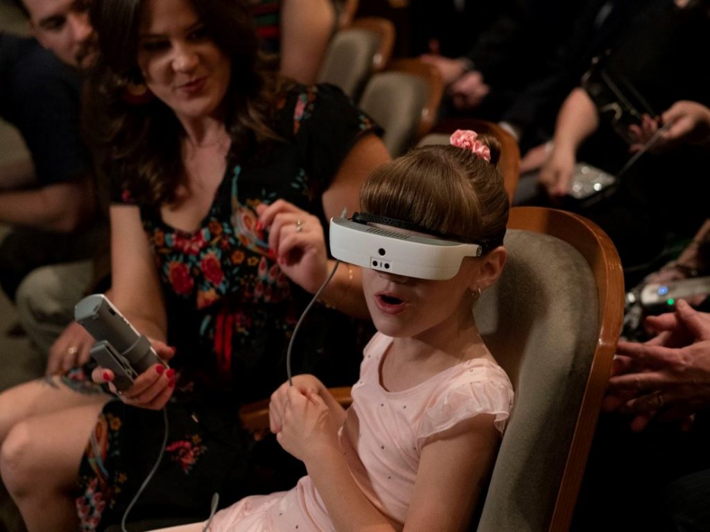 A little girl with low vision wearing eSight device