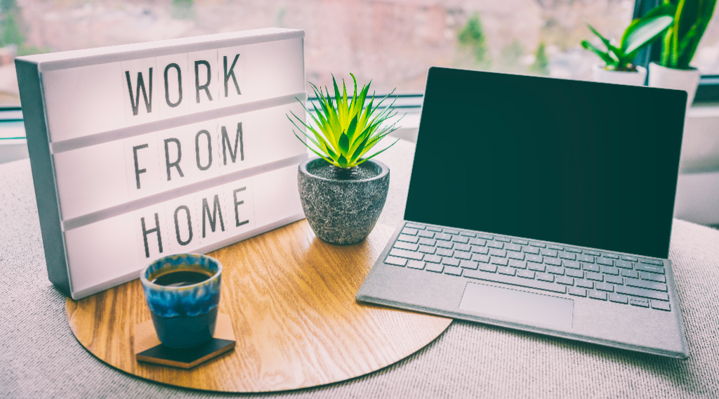 A laptop on the table with
a note on the left side saying work from home