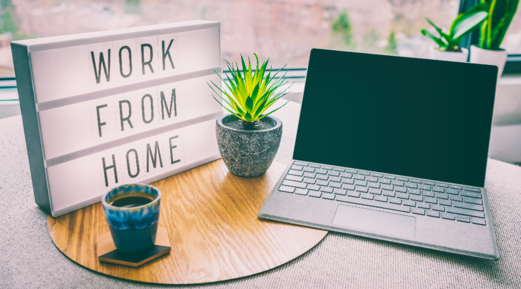 A laptop on the table with 
a note on the left side saying work from home