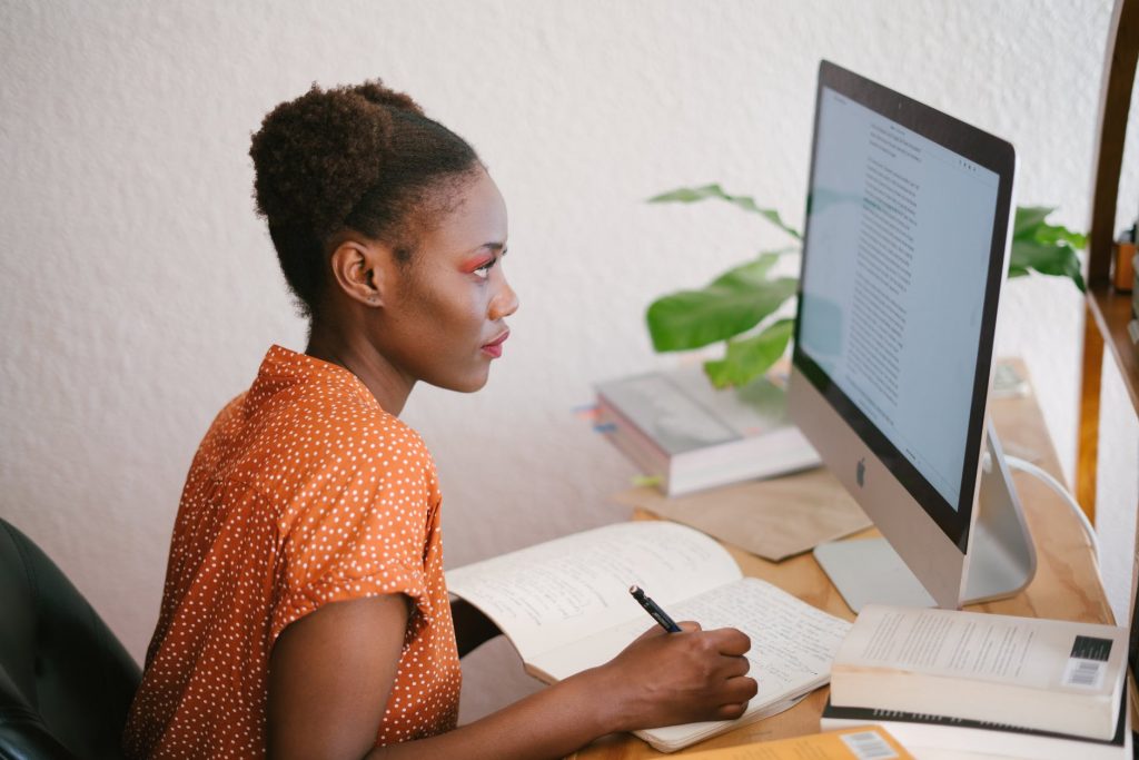 A girl sitting begind a desk at home