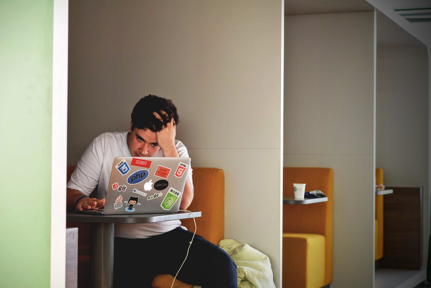 A guy working on his laptop looking frustrated