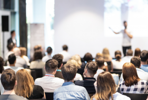 A classroom full of students and someone lecturing them