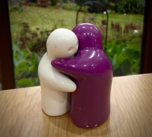 Purple and white salt and pepper hugging each other