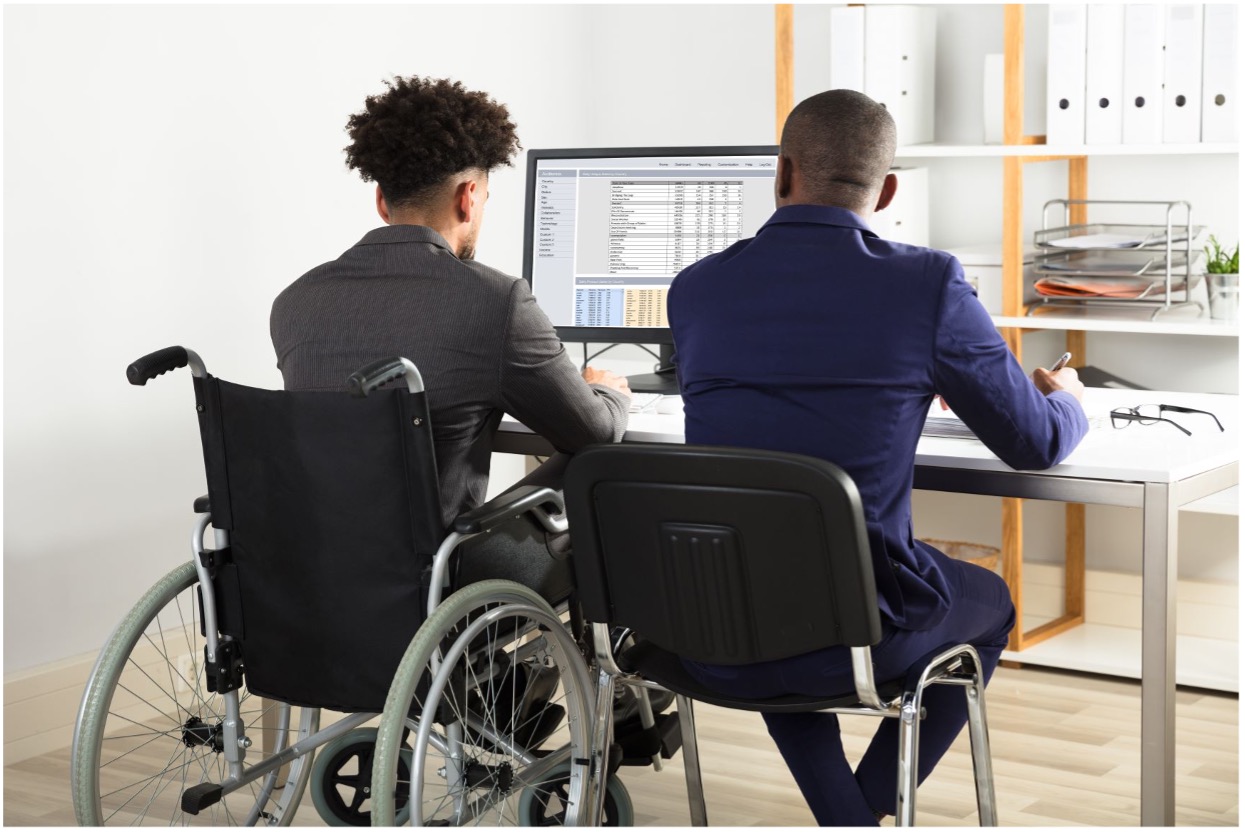 Two guys sitting on a wheelchair