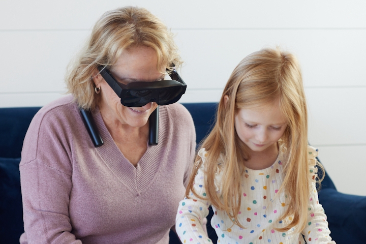 A woman using esight reading with a little girl